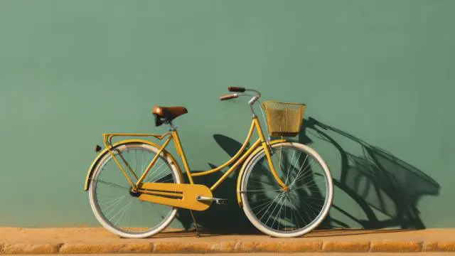 Olenbee - Olenmove - Mobilité : Vélo rétro jaune avec un panier, sur fond vert olive