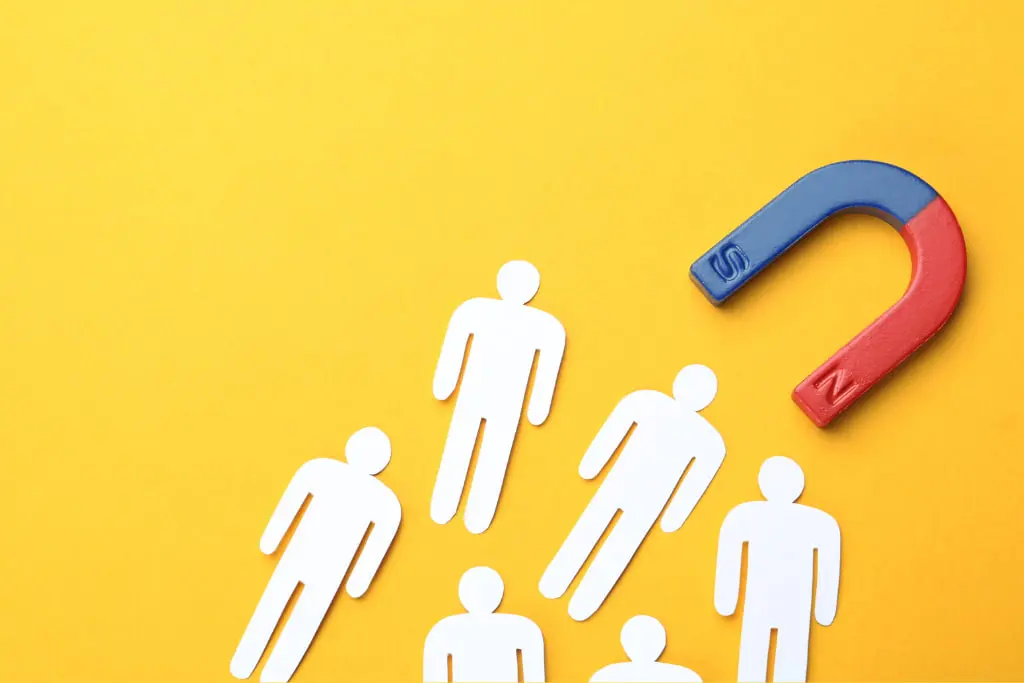 Aimant qui attire des silhouettes blanches, sur fond jaune