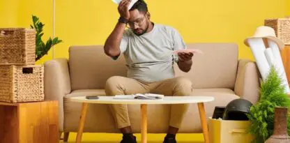 Photo sur fond jaune dans un salon avec un homme au centre, exaspéré par des papiers, une gestion complexe