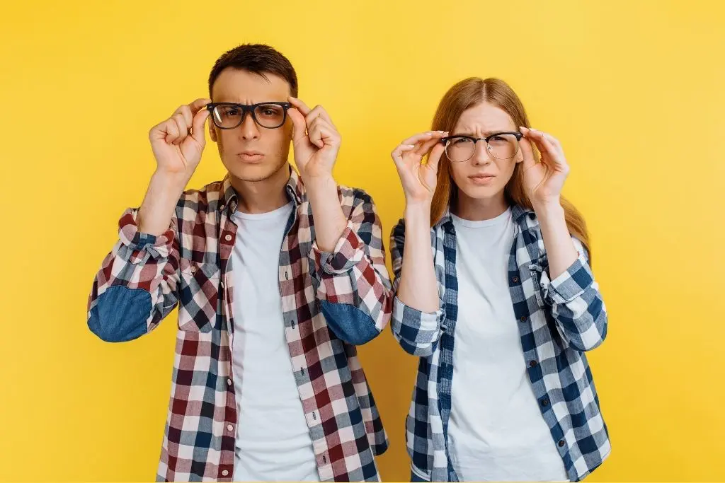 Sur fond jaune, un jeune homme et une jeune femme regardent la caméra en tenant leurs lunettes, l'air inquisiteur
