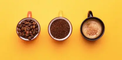 Sur fond jaune, trois tasses de café différentes vues du dessus