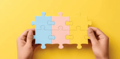 Sur fond jaune, deux mains tiennent des pièces de puzzle emboîtées