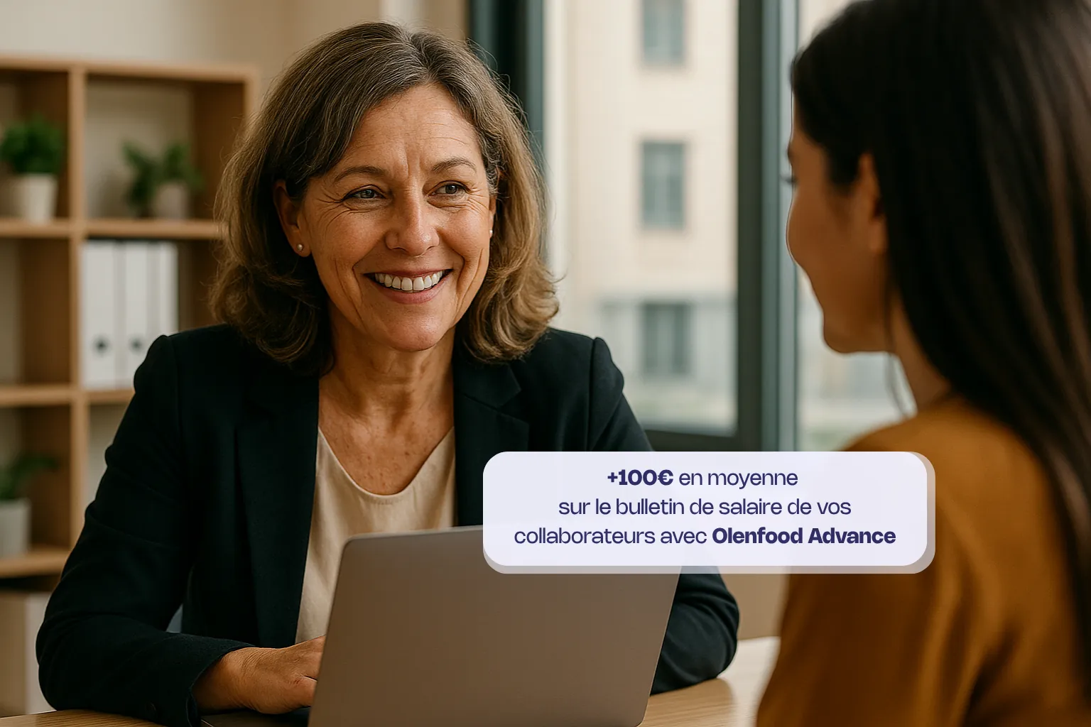 Assises de part et d'autre d'un bureau, une RH et une salariée se sourient. La RH est devant son ordinateur portable ouvert. On peut également lire une bulle d'information : "+100€ en moyenne sur le bulletin de salaire de vos collaborateurs avec Olenfood Advance"