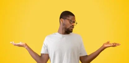 Sur fond jaune, photographie d'un homme qui balance ses mains et regarde l'une d'elle, hésitant à faire un choix