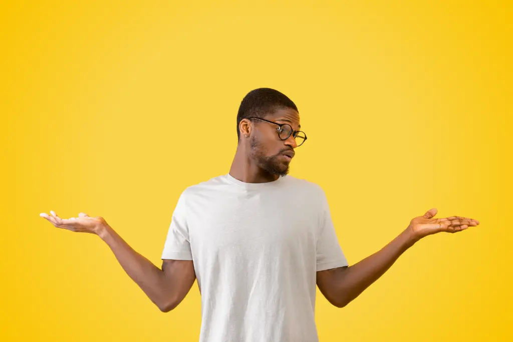 Sur fond jaune, photographie d'un homme qui balance ses mains et regarde l'une d'elle, hésitant à faire un choix