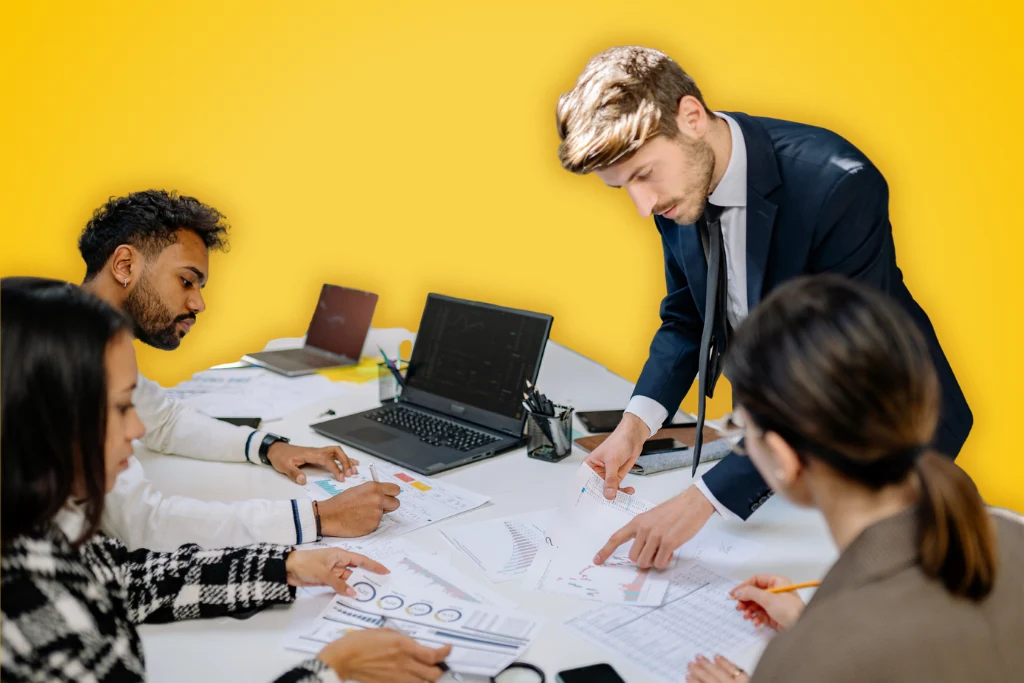 Sur fond jaune, une photographie d'une équipe qui travaille autour d'une table couverte de documents