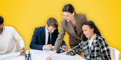 Sur fond jaune, une photographie candide d'une équipe qui travaille ensemble au bureau